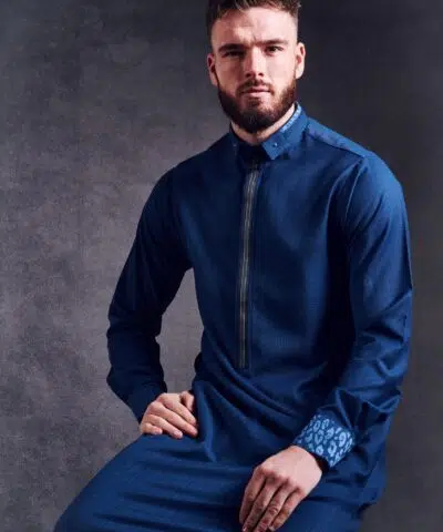 Homme assis avec une barbe portant un irrésistible Qamis Al Ameer AA2211 bleu.