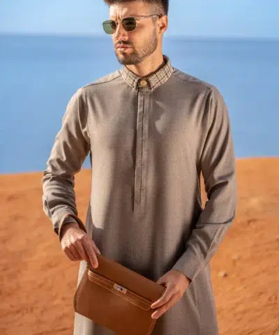 Homme dans le désert avec lunettes de soleil portant un élégant qamis al ameer aar2420 gris