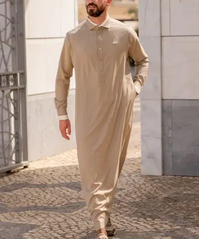 Homme chauve avec une barbe et des lunettes de soleil pourtant un magnifique qamis al ameer aar2423 beige.